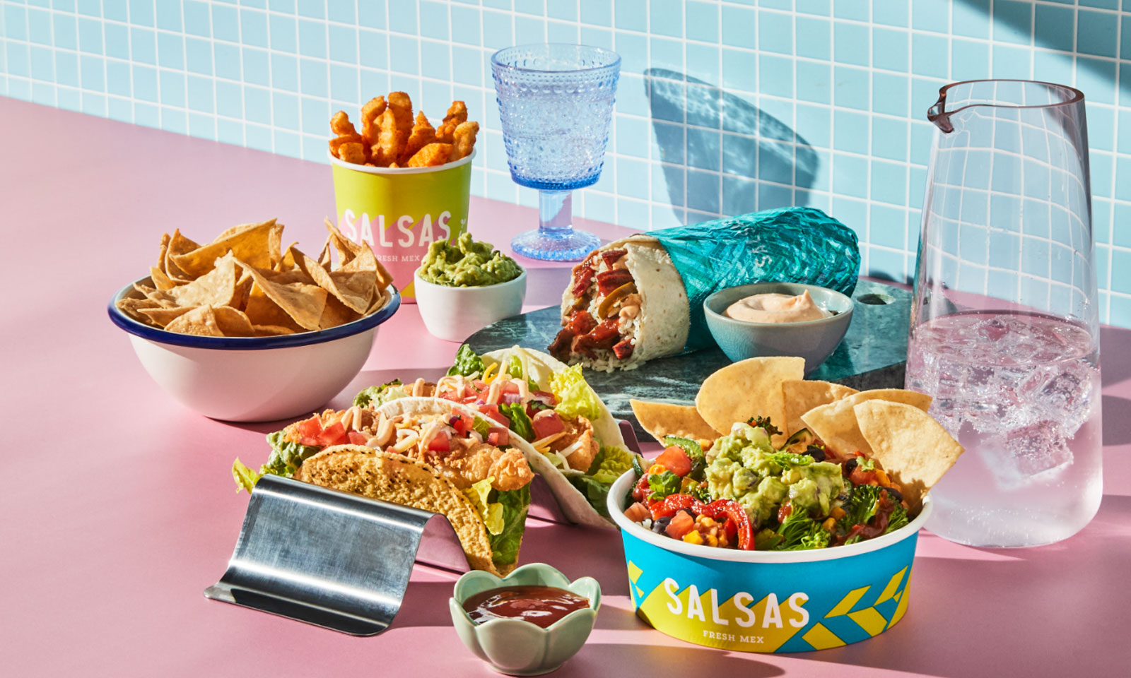 An overhead spread of Salsas tacos, sides and drinks